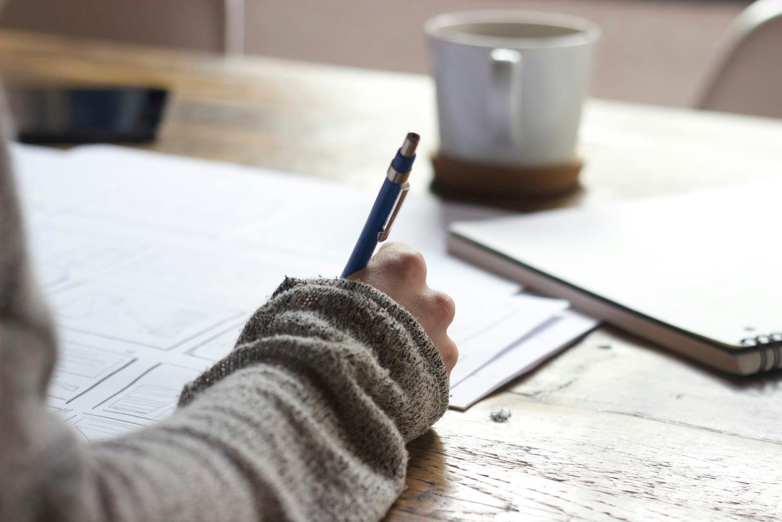 Person planning retirement with notebook and coffee