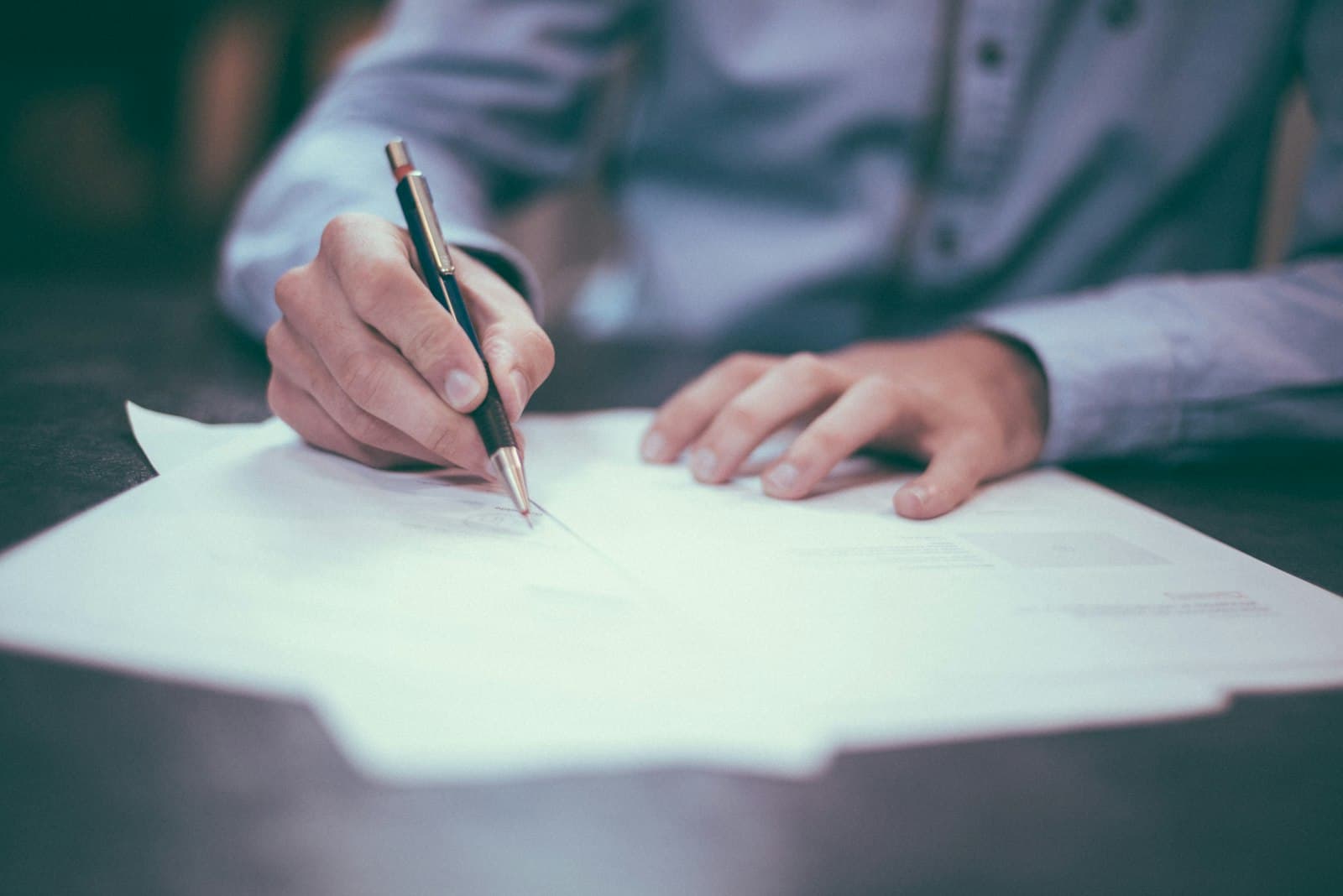 Hands filling out tax and financial planning documents